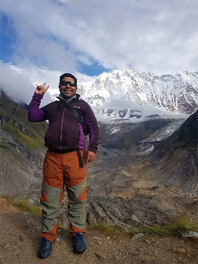 a man standing on a mountain with a peace sign